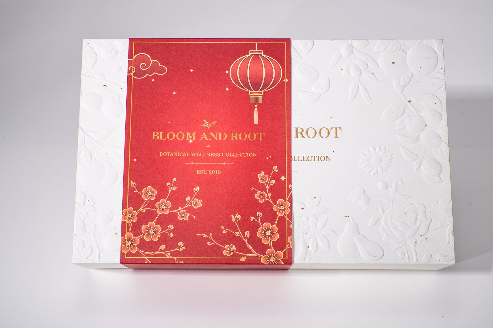 Bloom and Root gift boxes side by side showing embossed lid detail