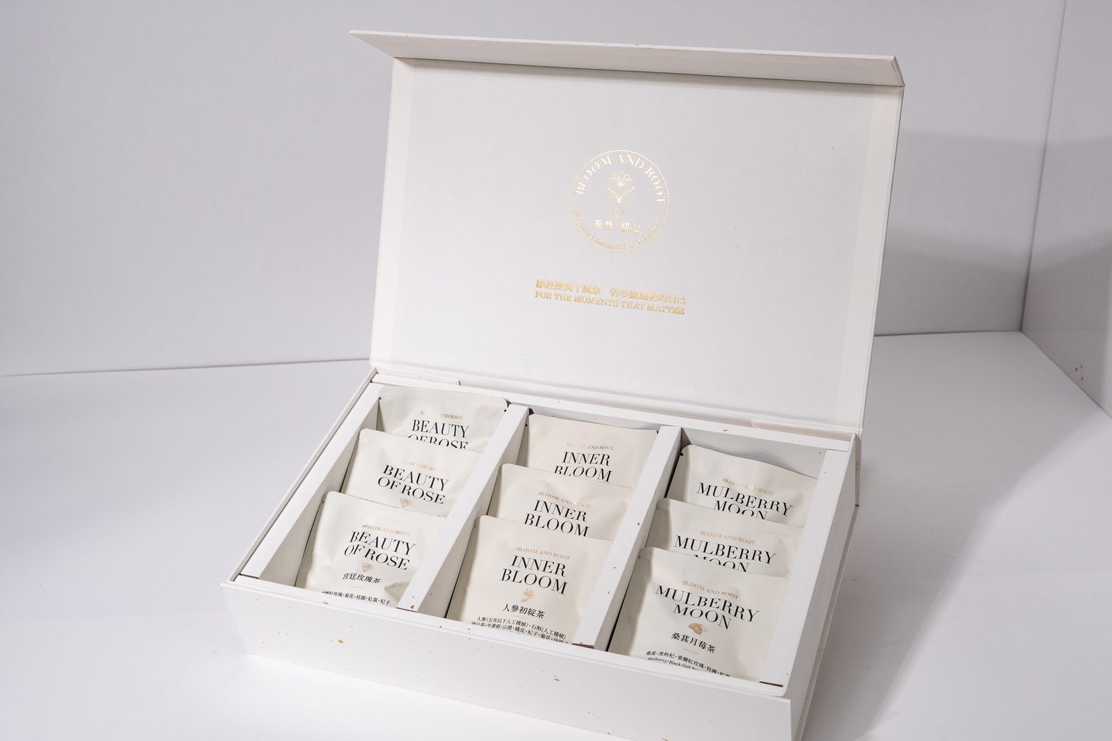Bloom and Root gift box open showing six labeled wellness tea sachet varieties
